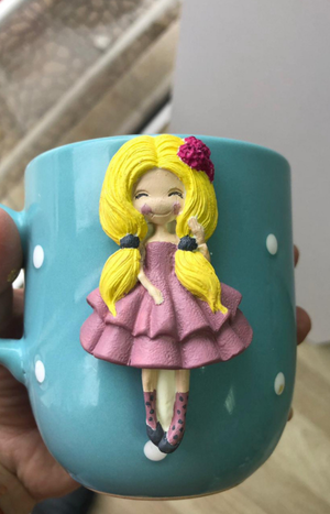 Silikon kalıp ile yapılmış, pembe elbiseli, sarı saçlı kız figürlü mavi seramik kupa.