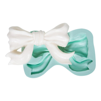 Büyük fiyonk silikon kalıbı ve kalıptan çıkmış beyaz fiyonk. Dekoratif süsleme için ideal.